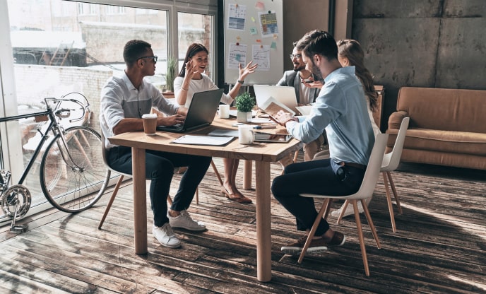Mobile-app-development-company-process-quality-assurance Mobile app development company experts going through a detailed quality assurance list at a team meeting