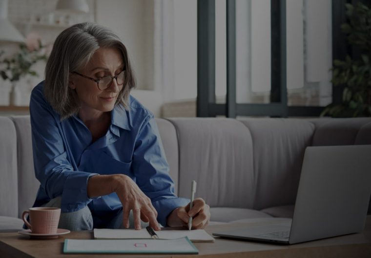custom-website-design-company-LIG-background-image woman writing down in her notes in a living room