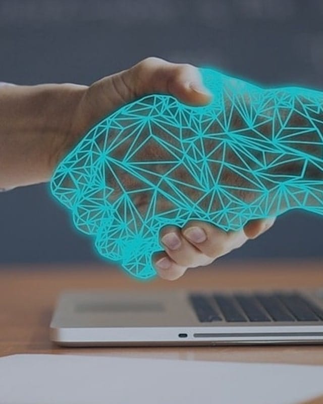 boston-materials-backgorund-4 Background image for Boston Materials' case study showing a handshake between a human hand and a digital wireframe hand over a laptop